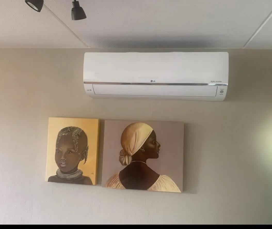 Wandmodel airco boven twee schilderijen